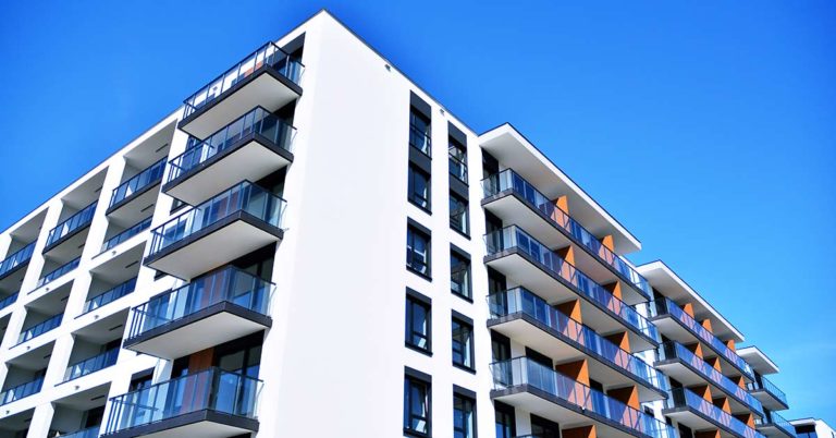 Modernes Mehrfamilienhaus mit blauem Himmel | Mehrfamilienhaus sanieren